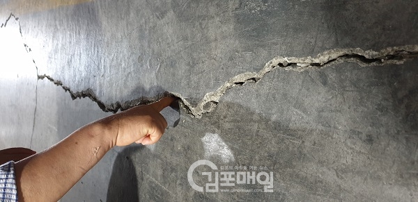 김포 지하철 지상대피 및 환기구 설치 발파작업 과정에 인근 건물 바닥에 균열이 일어나 곳을 피해를 입고 있는 회사관계자가 손을 넣어보고 있다.(사진=천용남기자)