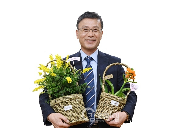코로나19로 어려움 겼는 화훼농가 꽃 팔아주기 캠페인에 동참한 정하영 시장이 양손에 꽃을 들어보이고 있다.(사진=김포시)