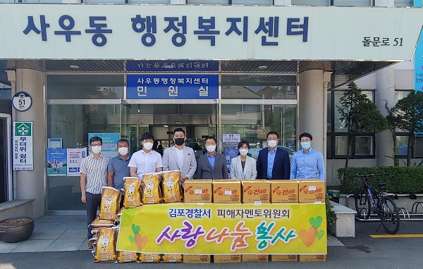 김포경찰서 피해자멘토위원회가 사우동 행복복지센터를 찾아 어려운 이웃에게 전달해달라며 쌀과 생필품을 전달, 기념사진을 찍고 있다.(사진=사우행복복지센터)