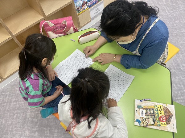 청수초 꿈마루도서관 에서 독서행사에 참여하고 있는 저학년 학생들이 엄마하고 속담 퍼즐을 즐기고 있다.(사진= 청수초)